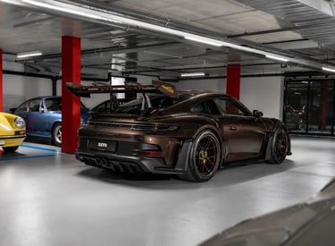 Traseira do Porsche 911 GT3 RS marrom exclusivo em garagem de colecionador