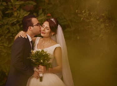 a bride and groom kissing in a garden