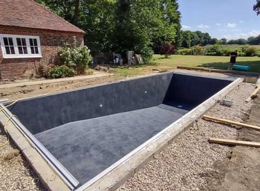 a concrete pool being built in the middle of a garden