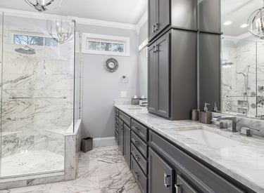 a bathroom with a marbled counter top and a shower
