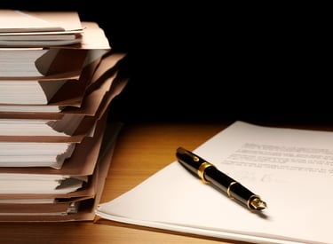 Elegant pen resting neatly beside neatly stacked files representing archival quality formatting.