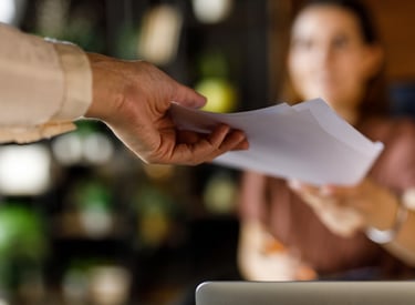 Steady hand passing a draft across the table representing cooperative editing