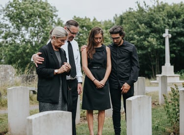 Family standing together at a cemetery, remembering a loved one with grace