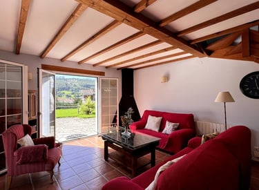 Sala de estar de la casa Mar con dos sofás, televisión y chiemenea