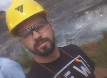  trabalhador equipado com capacete e óculos em meio a uma paisagem de mineração