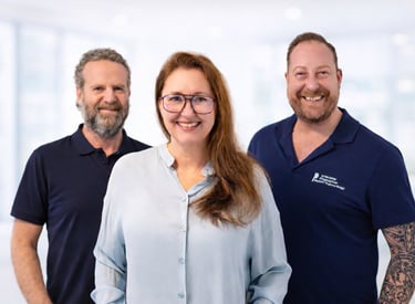 Smiling team of professional healthcare workers in uniform posing for a corporate group portrait.