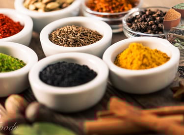 Various herbs and spices in white bowls
