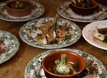 San Gemini, Il giardino - Vino e cucina - a table with plates of food and a bowl of food