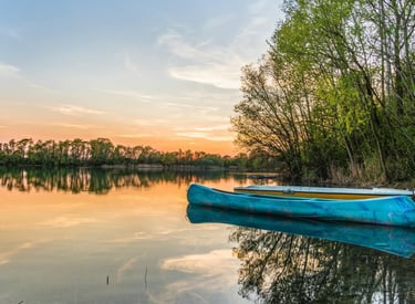 a blue boat on the water at sunset
