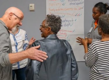 a group of people standing around a white board