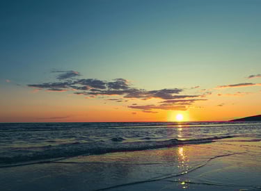 Un tramonto bellissimo visto dalla spiaggia, il sole che scompare nel mare
