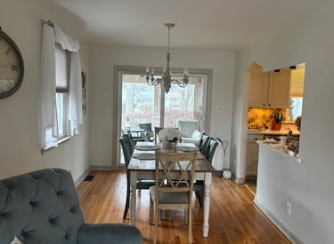 a finished painted dining room with a table and chairs