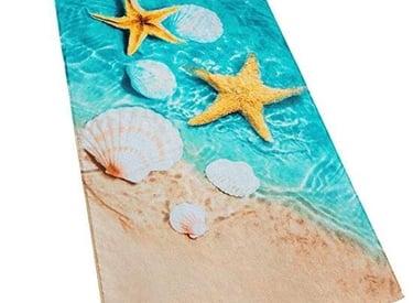 a beach towel with shells and starfishs on it