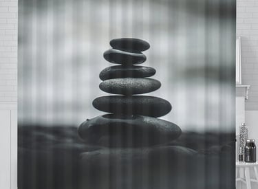 a black and white shower curtain with a stack of rocks