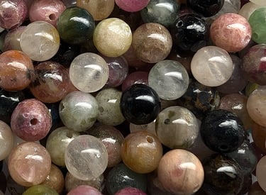 Perles en tourmaline colorée, aux nuances variées de rose, vert, noir et beige.