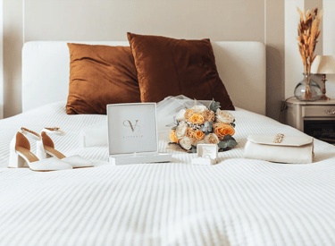 Accessoires de la mariée disposés sur un lit avant les préparatifs du mariage.