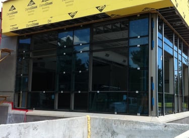 Commercial storefront under construction with modern glass windows and black frames