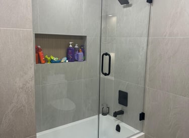 Frameless glass shower door installation with chrome hardware and modern design