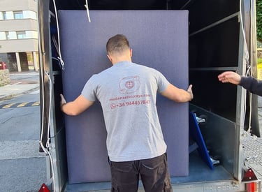 a man is moving a couch into a moving truck