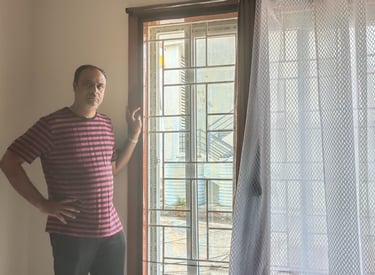 A close-up of a Velcro mosquito net neatly fitted on a wooden window frame in a Bangalore home.
