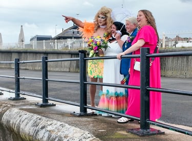 Couple just married with friends laughing at the beach