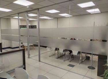 Divisorias para oficinas en cristal laminar de 5+5 mm. con puerta en vidrio templado de 10 mm. y lámina de vinilo opaca eca