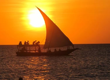 a sailboat sailing on the ocean at sunset
