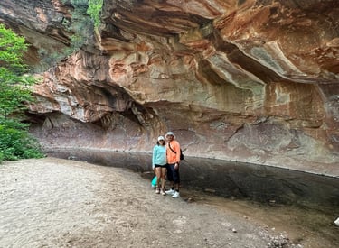 a couple of people standing in a cave in a cave