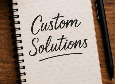 A notebook with the words "Custom Solutions" written on its open page.