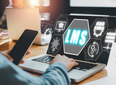 A glowing interface-style graphic reading LMS, rising off of a laptop screen.