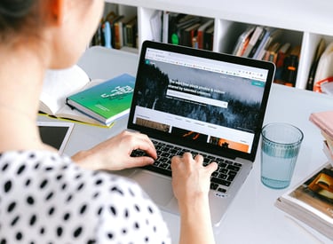 A woman sitting at a desk with a laptop computer
