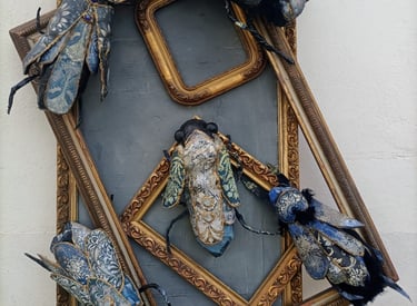 some picture frames with bugs climbing on them