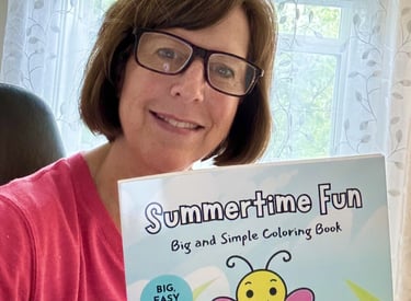 Photo of Laura Kane holding the Summertime Fun coloring book