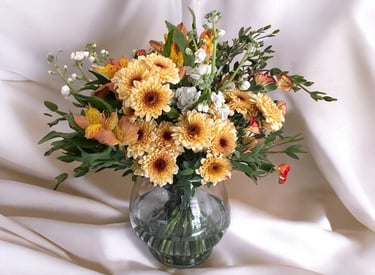 a vase with flowers in a vase on a white sheet