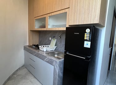 Dapur dan fasilitas umum di Kos Si Bos Surabaya dengan kulkas, wastafel, dan area bersih