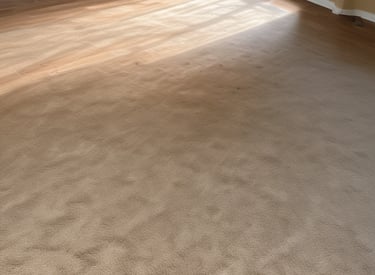 A contractor working on installing hardwood flooring in a home.