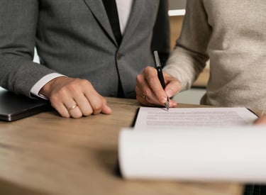 Personas firmando un contrato de compraventa inmobiliaria