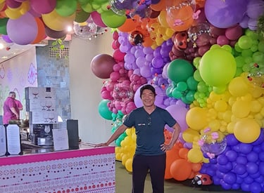 a man standing in front of a large display of balloons
