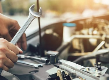 a man working on a car with a wrench