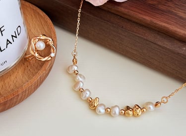 eine rosa Rose und ein Glas mit natürlichem Perlenschmuck auf einem Tisch