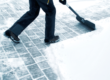 Winterdienst beim Schneeräumen auf einem Gehweg