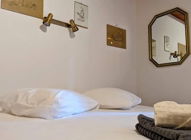 Un lit avec des dessins de nue au dessus et un miroir sur le côté