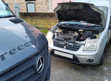 a van with bonnet up having engine diagnosed