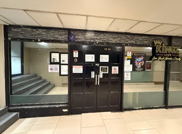Kingz Live entertainment venue entrance with black double doors, stone facade, and event posters.