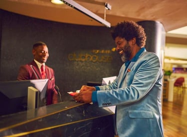 Man in suit checking in to Virgin Atlantic Clubhouse London Heathrow - Airport Lounge Guide