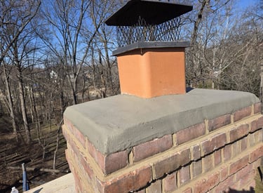 A newly installed concrete chimney crown and metal cap on a brick chimney by Roslyn Chimney