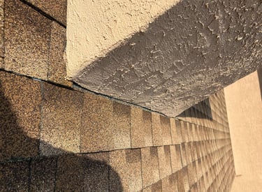 Damaged chimney flashing on an asphalt shingle roof, showing a common cause of water leaks, before repair by Roslyn Chimney