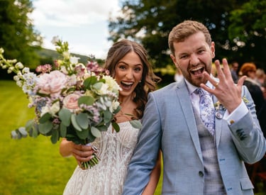 Bride and groom celebrating after ceremony at South Wales wedding, groom showing ring, captured candidly by Owen Mathias