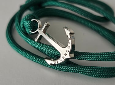 a silver anchor anchor on a green rope