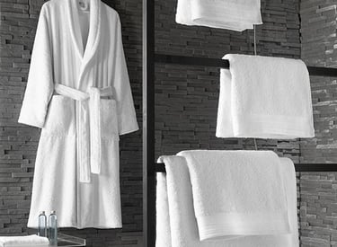 a bathroom with towels and robe on a towel